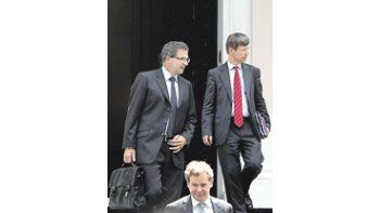 Los representantes de la troika, Poul Thomsen (FMI), Matthias Mors (UE) y Klaus Masuch (BCE), salen del Ministerio de Finanzas heleno tras acordar nuevo ajuste fiscal.