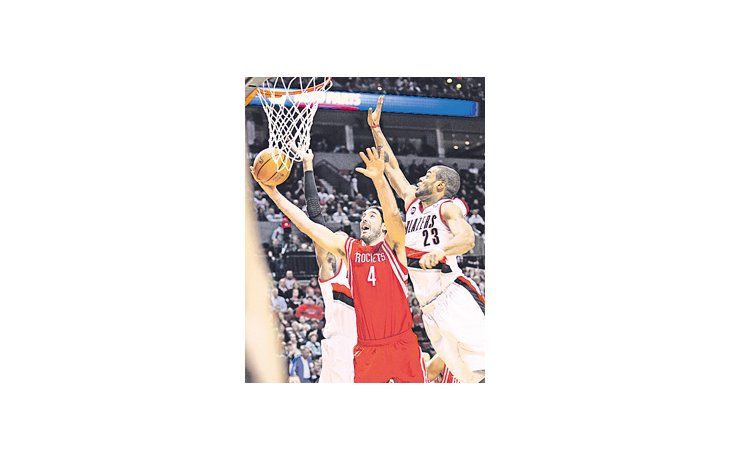 Luis Scola encesta ante la marcación de Marcus Camby. El argentino fue el goleador de los Rockets en el triunfo de su equipo ante Portland.