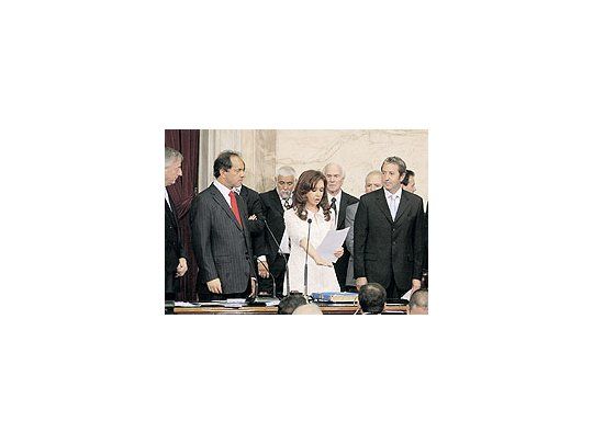 Traspaso de mando en elCongreso. La presidenteCristina de Kirchner juramientras el saliente NéstorKirchner, su vice JulioCobos y el ahora gobernadorde la provincia deBuenos Aires, DanielScioli, la observan condetenimiento.