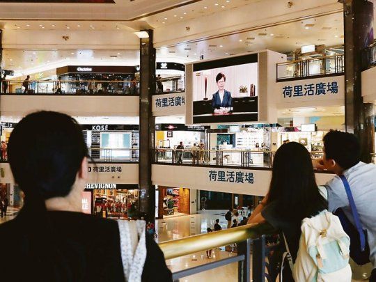 ANUNCIO. Hongkoneses observan la conferencia de la jefa del Ejecutivo, Carrie Lam. Se espera que al retirar la medida, terminen las protestas.