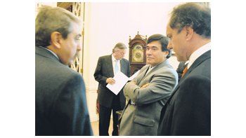 ámbito.com | Carlos Zannini en una charla, en Olivos, con Aníbal Fernández y Daniel Scioli. Atrás, Néstor Kirchner.
