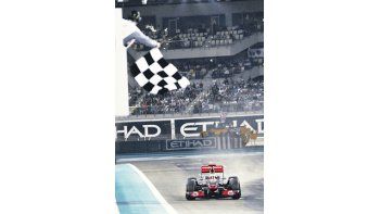 El McLaren del inglés Lewis Hamilton recibe la bandera a cuadros que lo consagra ganador del GP de Abu Dabi.