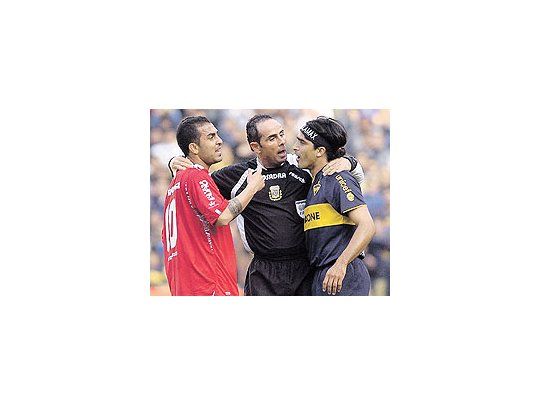 Pablo Lunati se interpone entre Montenegro y Morel Rodríguez. El árbitro fue protagonistadel partido con sus fallos polémicos. El empate entre Boca e Independiente fue justo.