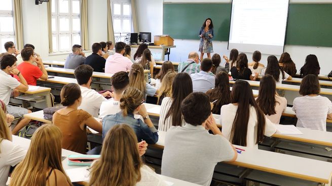 Alumnos universitarios en clase escuchando al profesor.