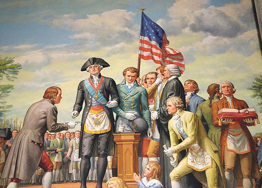 Washington, con atuendo masónico, colocando la primera piedra del Capitolio (arriba) en el Monumento Masónico al Padre de los EE.UU
