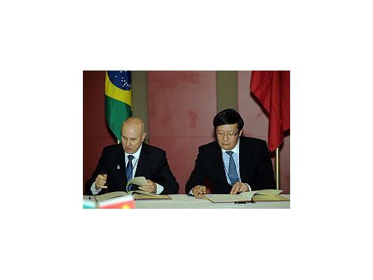 El ministro de finanzas brasileño, Guigo Mantega; y el Chino, Lou Jiwei; firman acuerdo antes de la apertura de la cumbre de los Países BRICS.