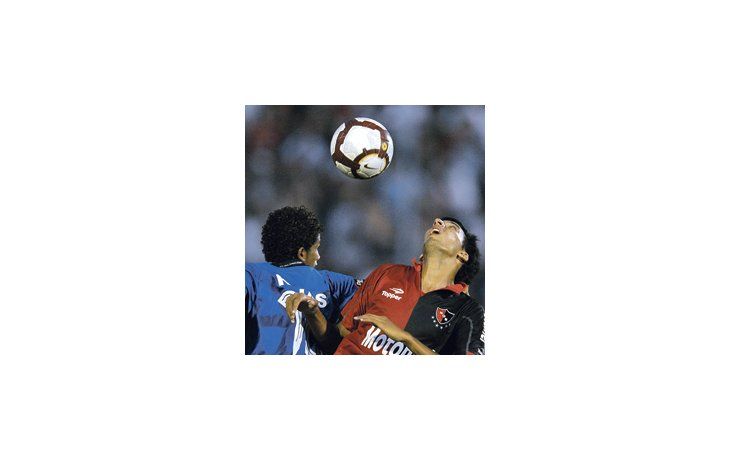 Lionel Vangioni va a disputar la pelota con Joao Rojas.