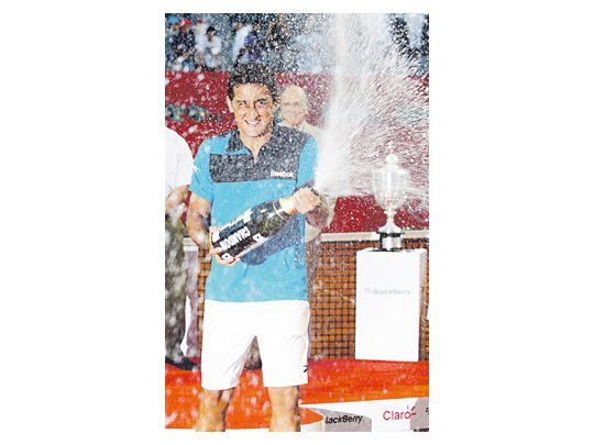 Nicolás Almagro festeja con champán tras obtener el ATP de Buenos Aires. Esta fue la tercera final consecutiva ganada por un español.
