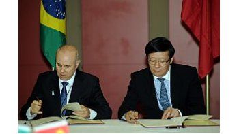 El ministro de finanzas brasileño, Guigo Mantega; y el Chino, Lou Jiwei; firman acuerdo antes de la apertura de la cumbre de los Países BRICS.