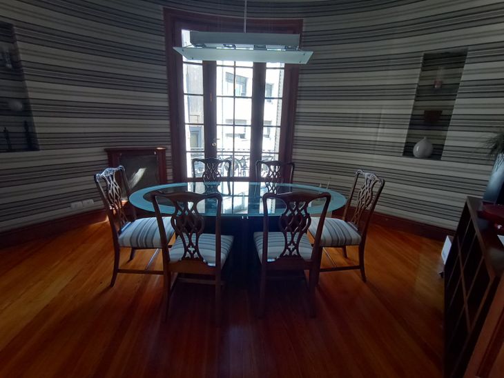 Ambiente interior con pisos de madera y salida a balcón, que conserva la impronta clásica de uno de los edificios del Pasaje