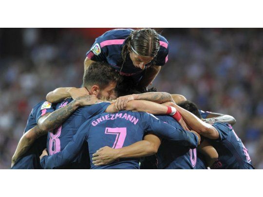 Los jugadores de Atlético de Madrid envuelven en un abrazo a Correa, quien abrió el marcador en el triunfo sobre Athletic Bilbao.