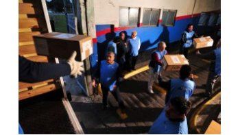 Varias filas de empleados pasaron las urnas de mano en mano hasta los camiones que las transportarán.