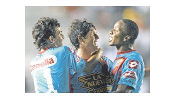 Jorge Córdoba y su primer grito con la camiseta de Arsenal. Felicitado en la foto por Carlos Carbonero y Emilio Zelaya. Los de Sarandí ganaron 3 a 0.