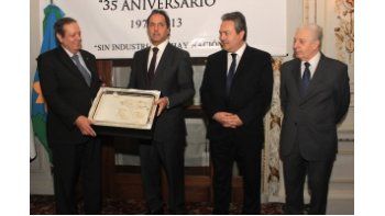 El gobernador Daniel Scioli entrega una placa al titular de la UIPBA por el 35 aniversario de la entidad.