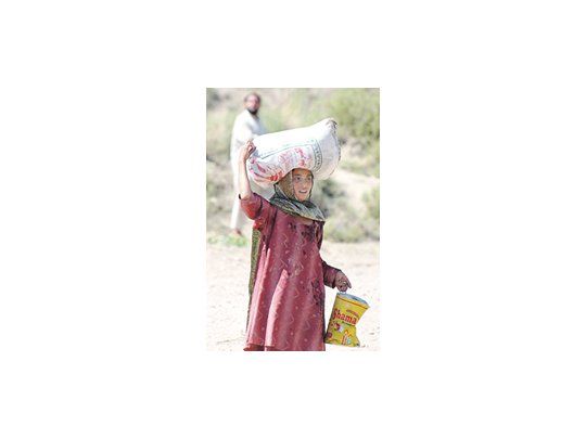 Una mujer se retira de un centro de distribución de comida en Kandaro, una localidad paquistaní.