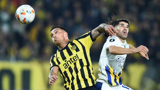 El defensor uruguayo Javier Méndez disputa la pelota con Ignacio Malcorra, en el partido en el que Rosario Central perdió 2-1 ante Peñarol, en Montevideo, e implicó la eliminación de la Copa Libertadores.