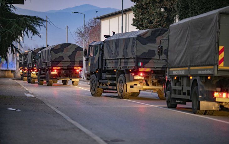 Un convoy de camiones transportando ataudes por las calles de Bergamo.
