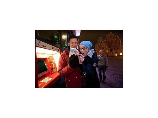 Dos jóvenes retiran euros de un cajero automático en la capital letona.