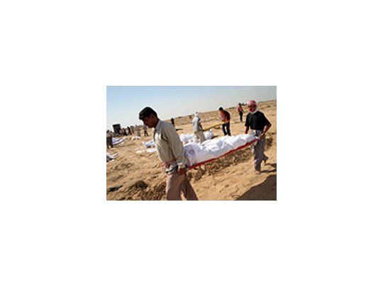 Dos hombres cargan uno de los cuerpos sin identificar encontrados en las cercanías de Bagdad.