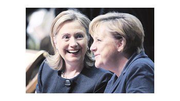 Hillary Clinton sonríe mientras dialoga con la jefa de Gobierno alemana, Angela Merkel, en el inicio de la cumbre de la Organización para la Cooperación y el Desarrollo en Europa, en Astaná, Kazajistán. El Wiki-escándalo dominó la cita.
