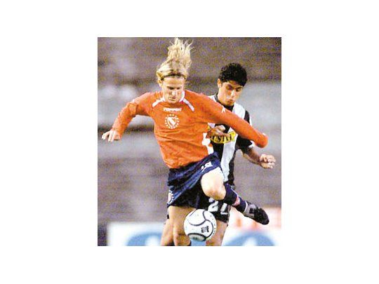 Diego Forlán pelea la pelota con el defensor chileno.