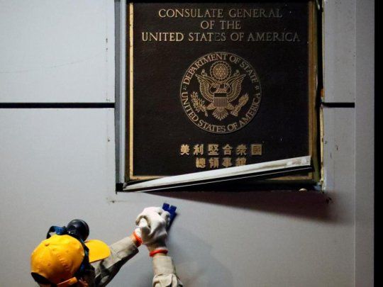 Un funcionario chino retira la placa de identificaci&oacute;n del consulado de Estados Unidos en Chengdu.