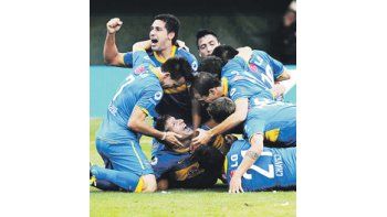 ámbito.com | Debajo de la montaña humana está Martín Palermo con la boca llena de gol. Boca ganó el superclásico por practicidad y complicó a River en el promedio. No fue superior en el juego, pero aprovechó un insólito error de Juan Pablo Carrizo y la capacidad golea