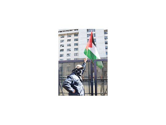 Un manifestante, de los cien que concurrieron ayer a Comodoro Py para reclamar la libertad de cinco acusados por el ataque antisemita del domingo, blande una bandera palestina.