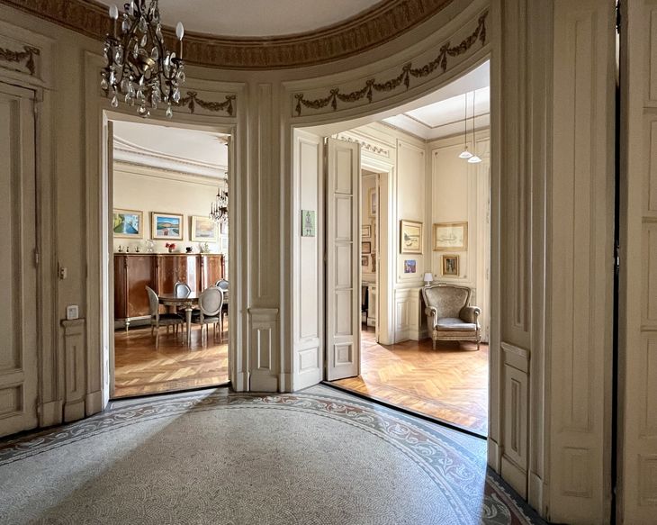 Hall curvo de acceso con mosaicos calcáreos, que organiza la circulación hacia el área social y privada del departamento Hall curvo de acceso con mosaicos calcáreos, que organiza la circulación hacia el área social y privada del departamento