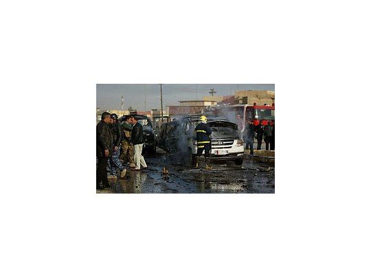 Los bomberos intenta apagar unos los coches que estalló en Bagdad.