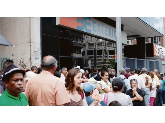 FILAS ETERNAS. Los venezolanos hacen cola a diario para retirar dinero en efectivo. La mercancía que se compra con tarjeta de débito o crédito puede llegar a valer el triple que abonando con billetes.