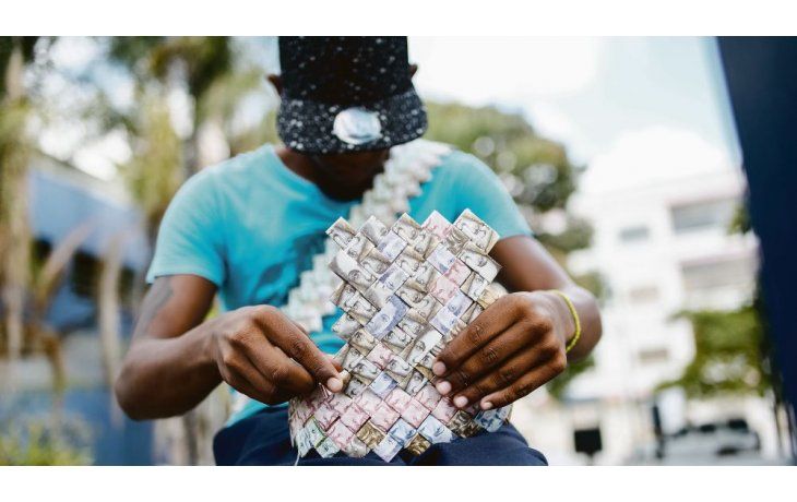 ámbito.com | ARTE. Jóvenes artistas utilizan los devaluados bolívares para hacer manualidades que venden en las calles de Caracas. Muchos venezolanos se desprenden de los billetes por la pérdida de su valor.