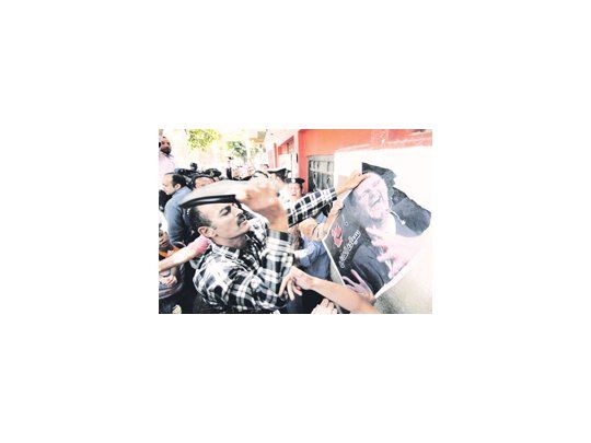 Un sirio exiliado en Egipto golpea con su zapato una foto del dictador Bashar al Asad. El régimen de Damasco ha apelado a una represión sin cuartel contra los manifestantes prodemocráticos.