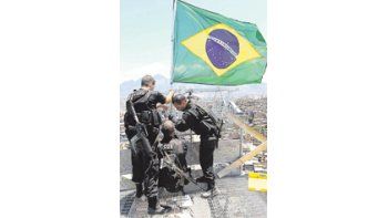 Policías brasileños colocaron ayer la bandera nacional en lo alto del Complexo do Alemao, arrebatado a los jefes del narcotráfico que habían predominado allí durante años. La presencia policial y militar en la nueva megafavela «liberada» se prolongará en el tiempo, atendiendo al temor popular de que el espectacular operativo de ayer no impida un retorno de los mafiosos.