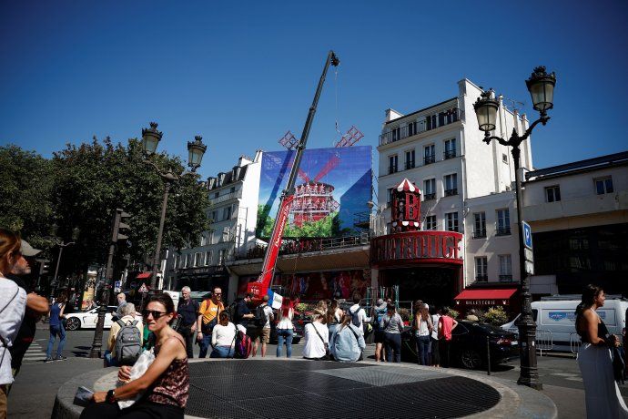 The Moulin Rouge cabaret in Paris, whose iconic windmill blades collapsed onto the street in April, received new blades today, although they cannot be turned until after the Olympic Games. The Moulin Rouge cabaret in Paris, whose iconic windmill blades collapsed onto the street in April, received new blades today, although they cannot be turned until after the Olympic Games.