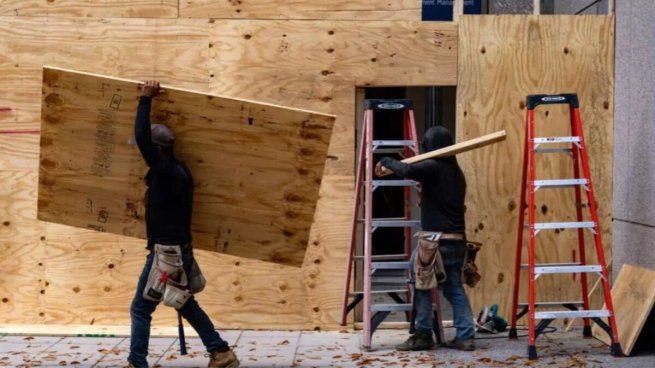 Algunos comerciantes están martillando sus negocios con tablones de madera.