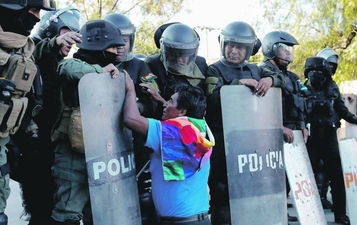 ruego. Un simpatizante de Evo Morales se arrodilla frente a un piquete policial durante una manifestaci&oacute;n en Cochabamba, una de las ciudades en las que m&aacute;s se ha sentido la represi&oacute;n.