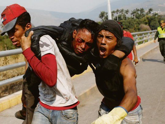 DISTURBIOS. Manifestantes cargaban el cuerpo de un herido de gravedad durante nuevos enfrentamientos en la frontera entre Colombia y Venezuela.