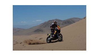 Coma con su KTM entre las dunas del desierto.