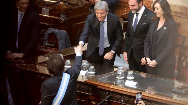 Luis Caputo saluda a Milei durante la presentación del Presupuesto 2025.