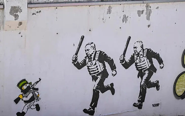 Mural de A. Palombo en Tel Avivi, mostrando a Netanyahu y Gadi Eisenkot con chalecos antibalas, corriendo a los bastonazos a Bart Simpson vestido como guerrillero de Hamas. Gane uno u otro hay cosas que no van a cambiar en Israel.