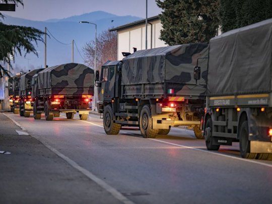 Un convoy de camiones transportando ataudes por las calles de Bergamo.