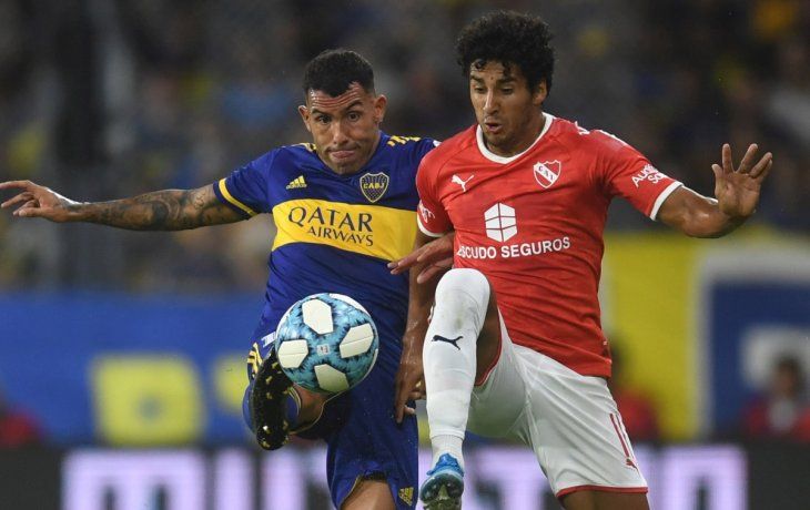 Carlos Tevez disputa la pelota con Cecilio Dom&iacute;nguez. El delantero de Boca no tuvo un buen partido.
