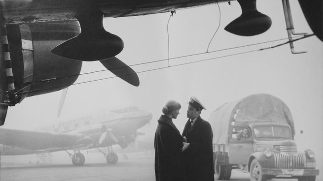 George Friedman, Sin título. 1956. Gelatina de plata sobre papel. La imagen de una pareja junto a un avión a hélice acaso inspirada en “Casablanca”.