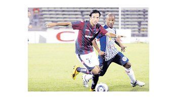 Juan Carlos Menseguez supera a Carlos Sánchez. El ahora volante convirtió el primer gol del partido, el segundo en su cuenta personal, y abrió la posibilidad para un gran triunfo de San Lorenzo.