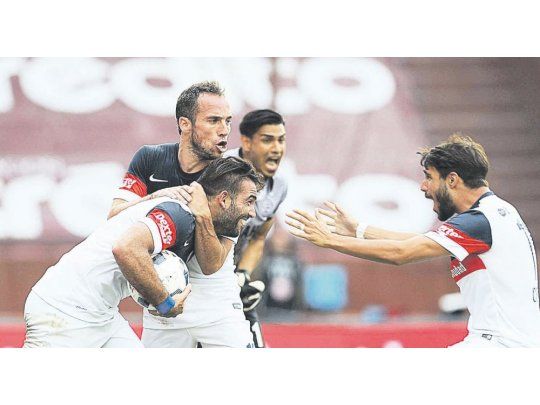 Desahogo. Cauteruccio convirtió el segundo gol y lo festeja junto a Belluschi y Cerutti. San Lorenzo supo reaccionar a tiempo y tras ir perdiendo por dos tantos de diferencia logró empatarle a Lanús.