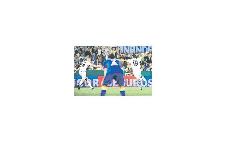 Fernando Ortiz por un lado y Santiago Silva por el otro festejan el único gol del partido, mientras, fuera de foco Matías Caruzzo se lamenta. Vélez ganó 1 a 0.