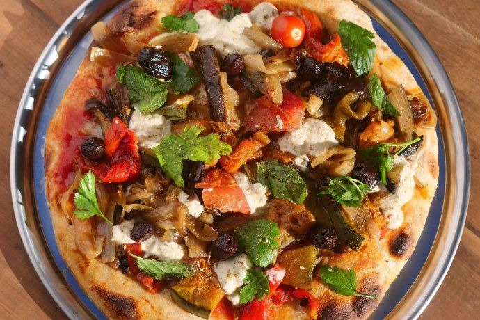 Entre sus especialidades se encuentra la Pizza Libanesa, una opción vegana hecha con salsa cocida y verduras asadas en horno de leña. Entre sus especialidades se encuentra la Pizza Libanesa, una opción vegana hecha con salsa cocida y verduras asadas en horno de leña.