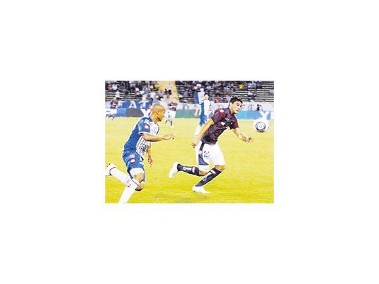 Nahuel Benítez supera a Carlos Sánchez, en el partido del lunes ante Godoy Cruz. El delantero se rompió los ligamentos al chocar con Torrico, cuando marcó su gol.