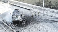 ALERTA. Soldados custodian uno de los ingresos de Kiev, mientras que imágenes satelitales muestran a un convoy militar ruso dirigiéndose a la capital ucraniana.